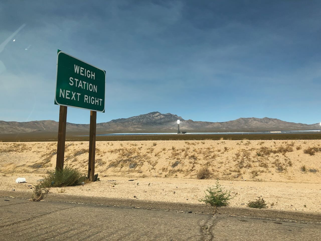 Picture of solar farm with weigh station sign in the foreground